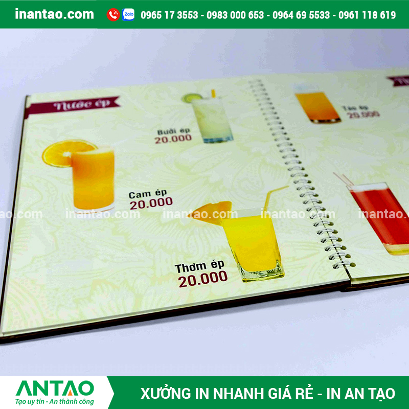  Mẫu menu cafe thiết kế sáng tạo, đặt trên bàn gỗ cùng ly cà phê, dịch vụ in nhanh lấy liền của An Tạo.